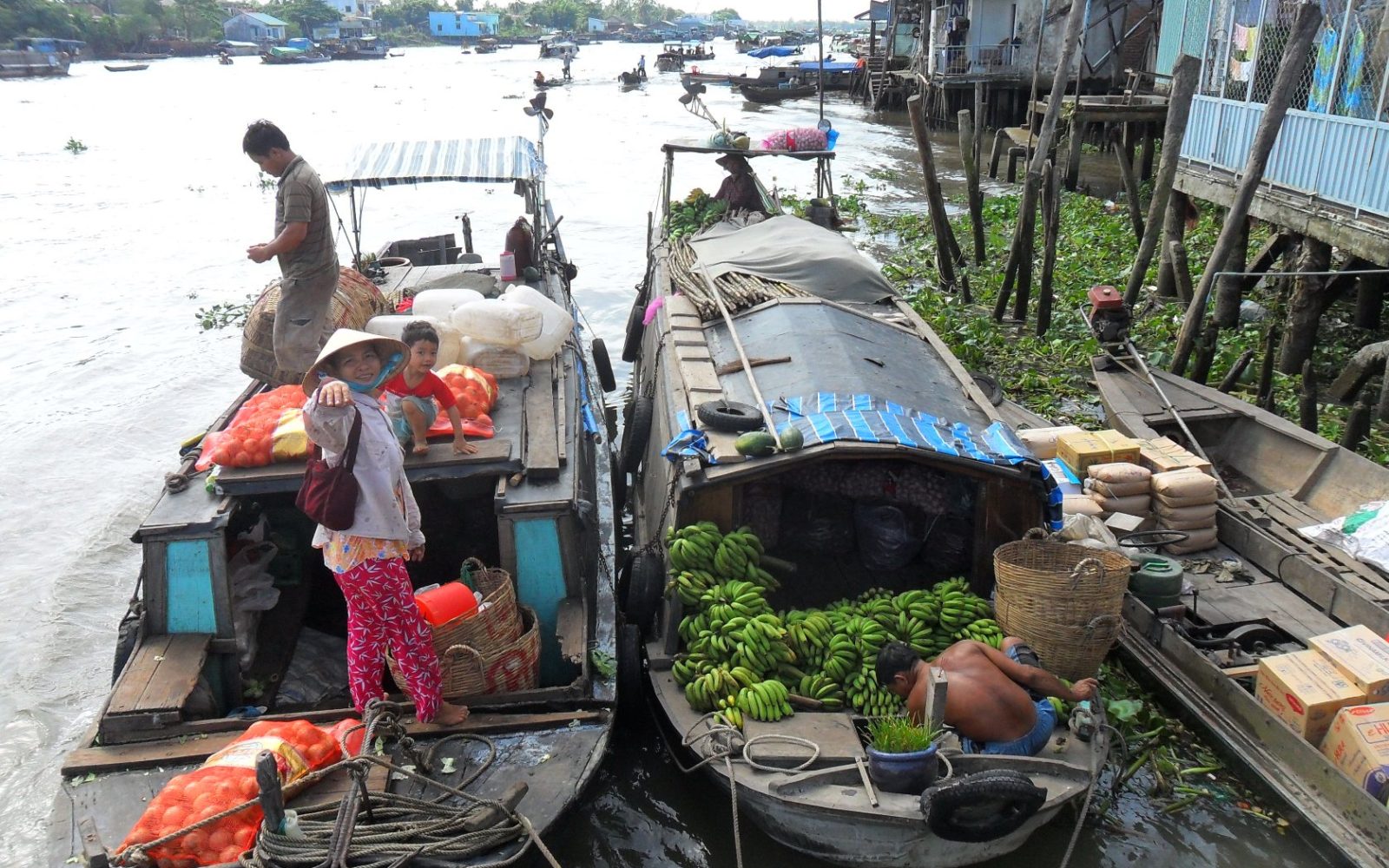 Thuyền chở người và nông sản trên một nhánh sông miền Tây